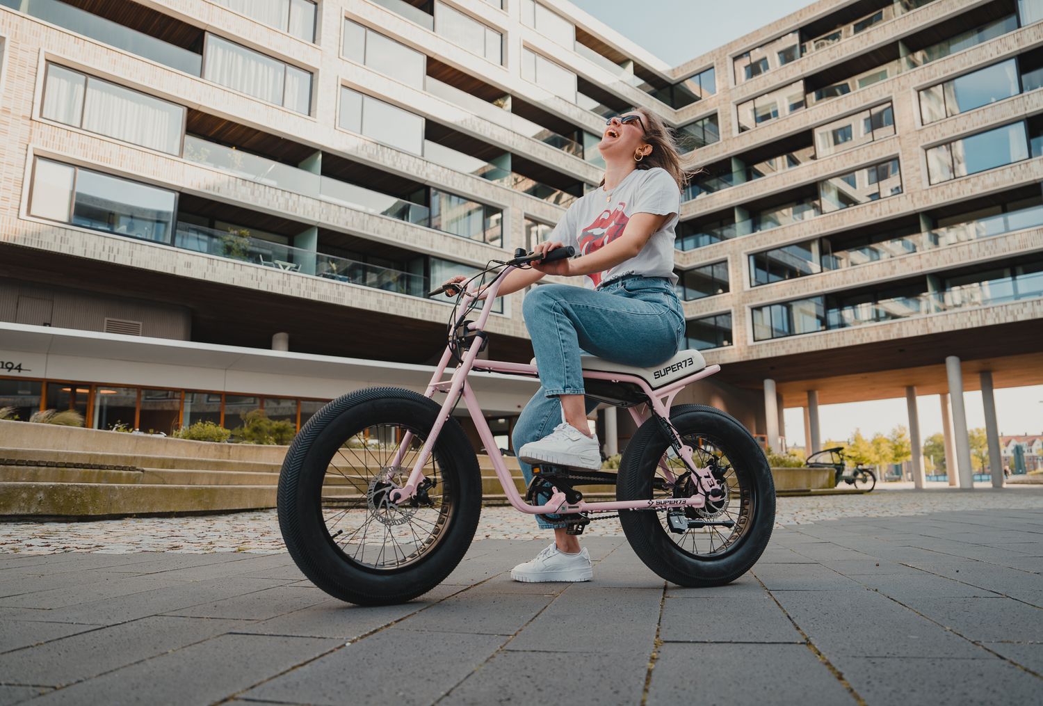 Low angle view of electric bikes against urban residential building backdrop.