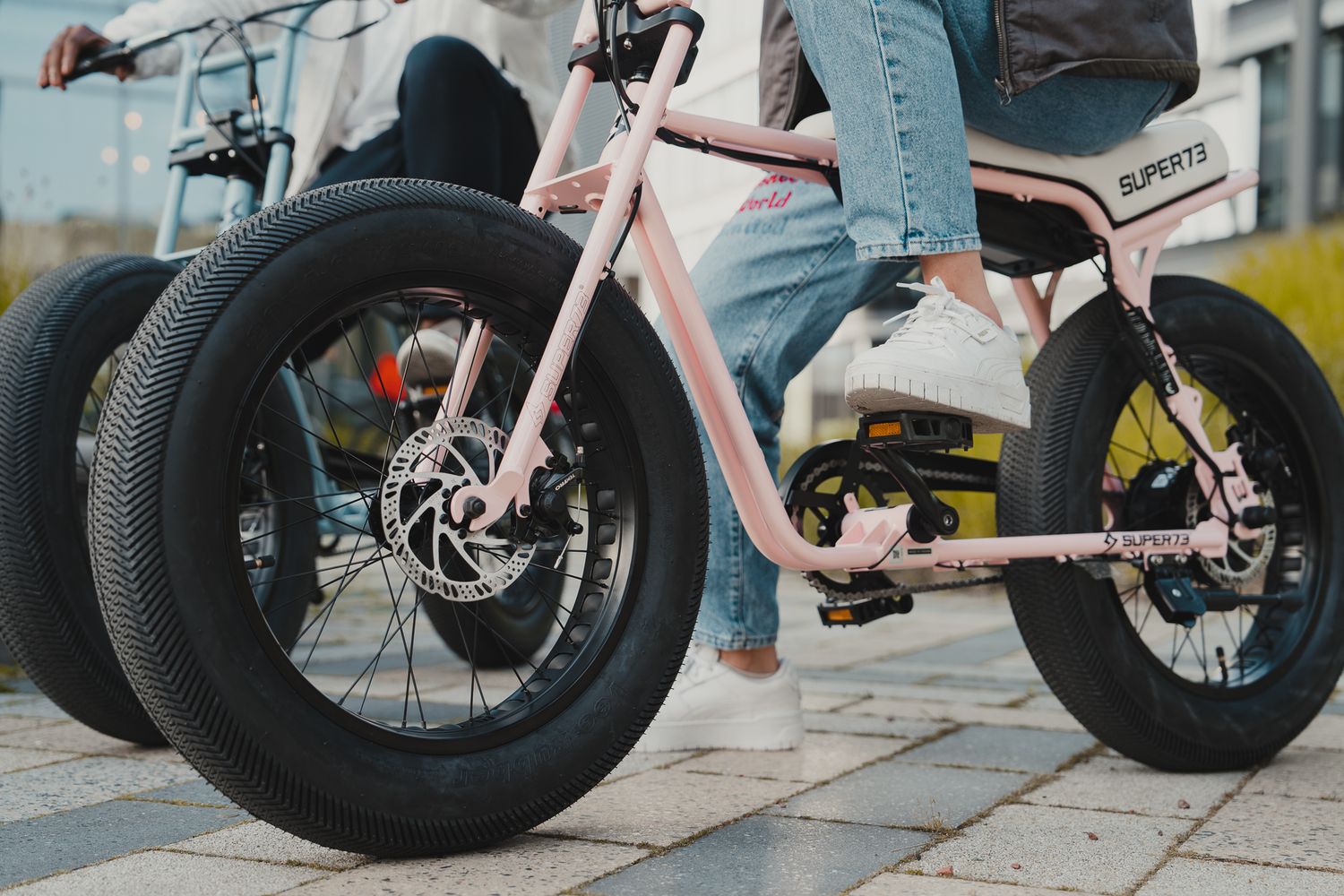 Close-up view of pink electric bike wheels and frame details.