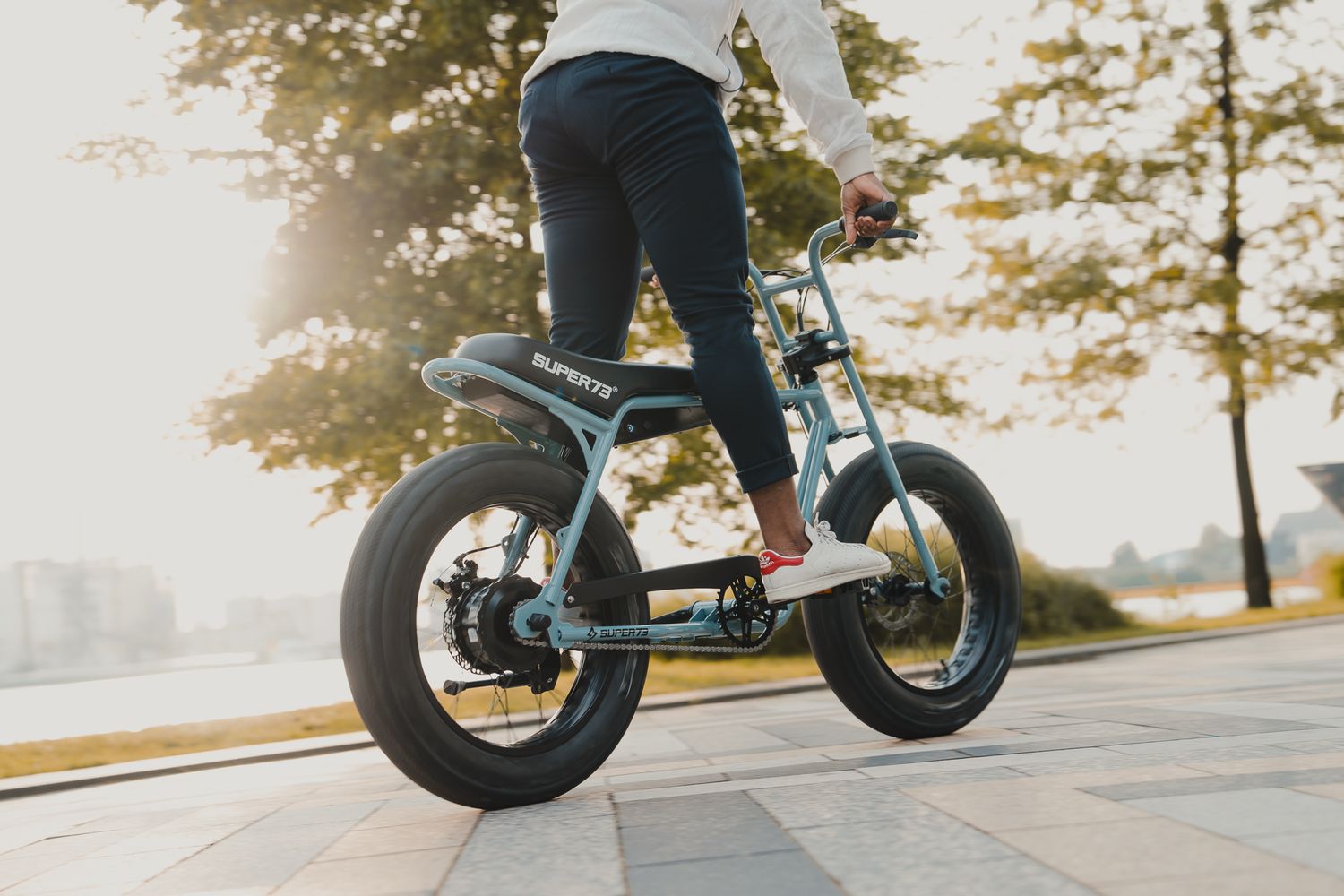 Electric bike with wide tires cruising along sunny outdoor path.