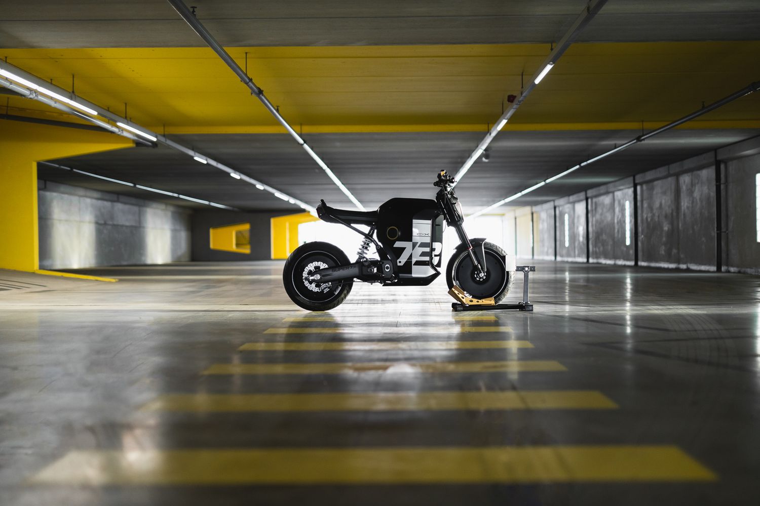 Dramatic low-angle shot of motorcycle in yellow-lit underground parking garage.