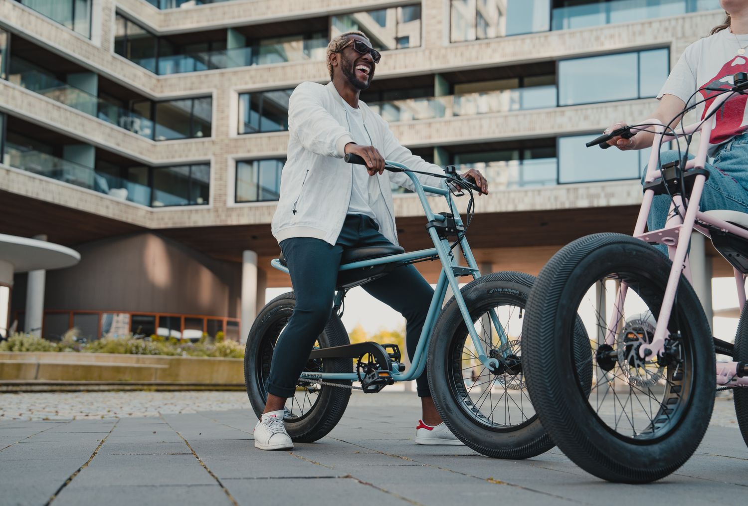 Side view of electric bikes displayed in front of contemporary residential architecture.