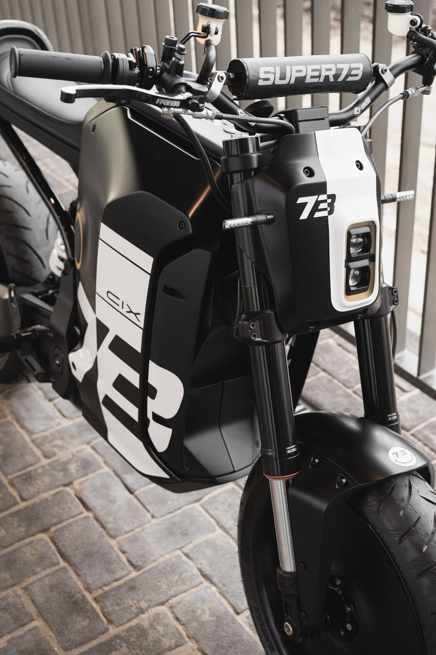 Close-up details of a modern electric motorcycle's handlebar and control interface.