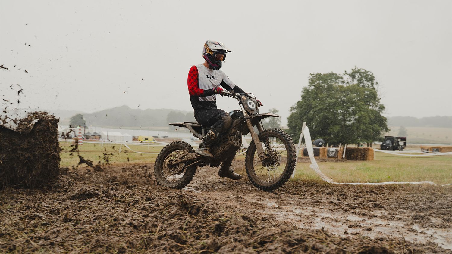 Motorcyclists riding through muddy terrain on dirt bikes.