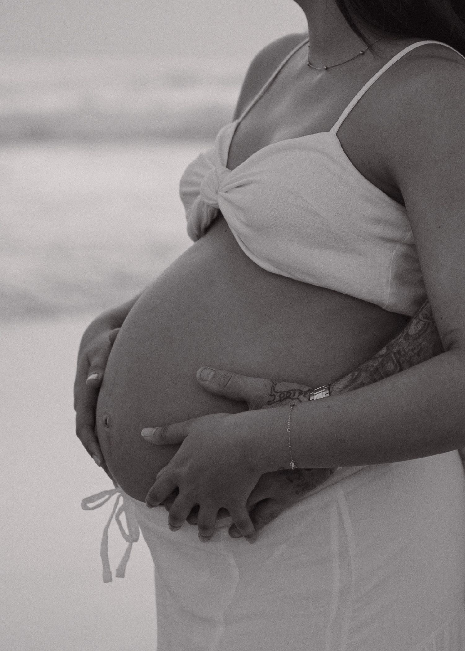 A black and white photo series showing a pregnant woman's growing belly at different stages of pregnancy.