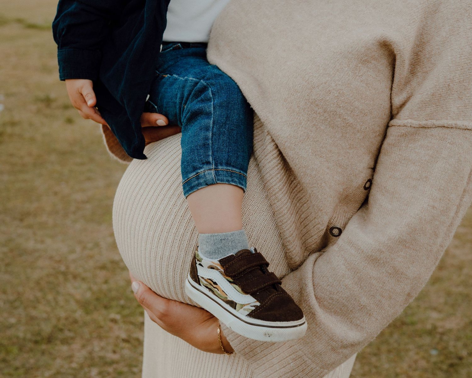 Close-up view of casual clothing details during an intimate outdoor family photoshoot.