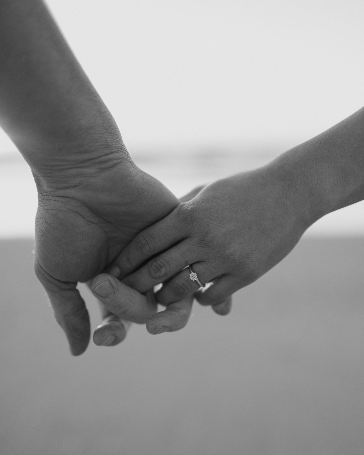 Close-up black and white shots of hands holding each other in sequence.