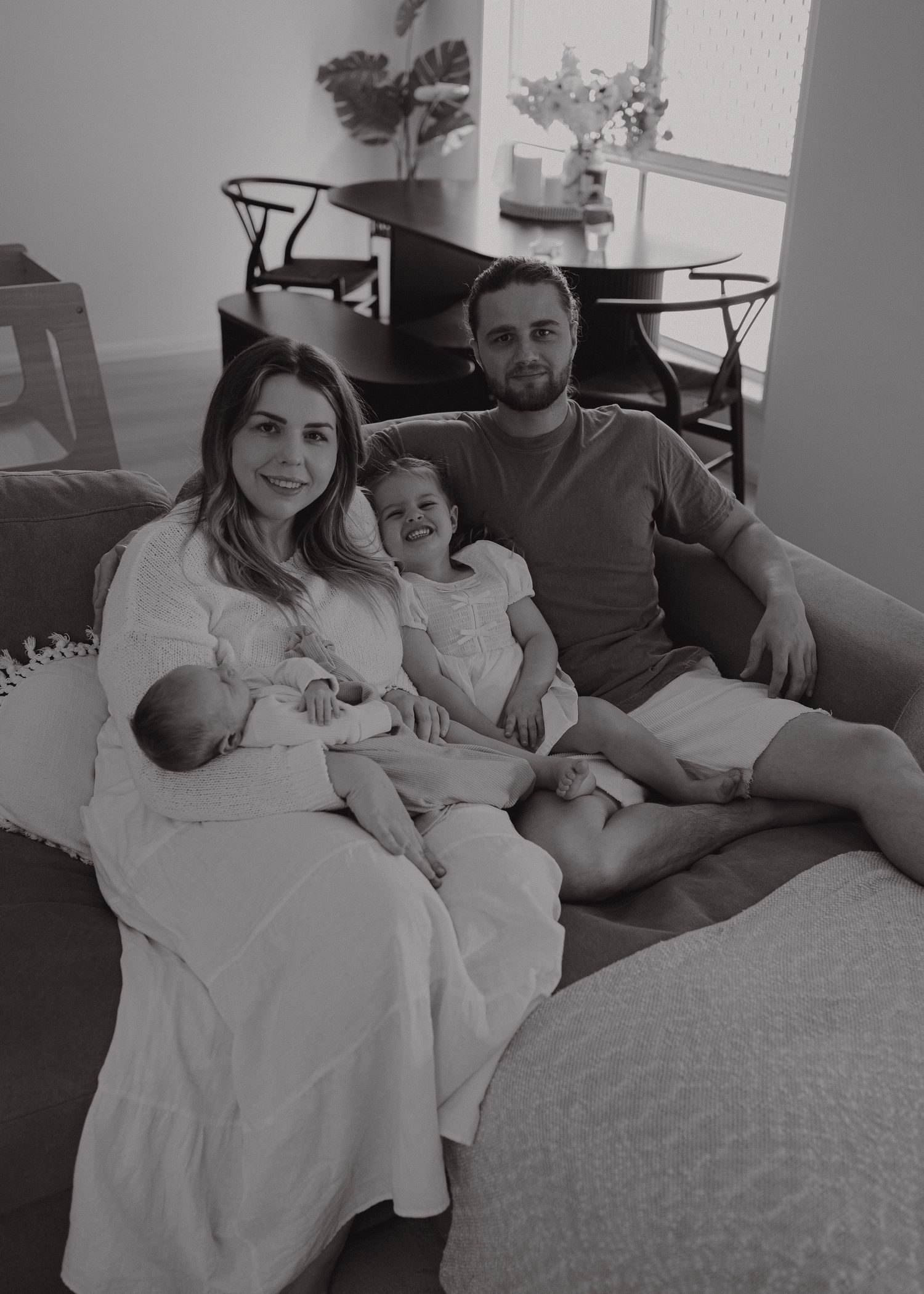 Family spending quality time together on grey couch in living room setting.
