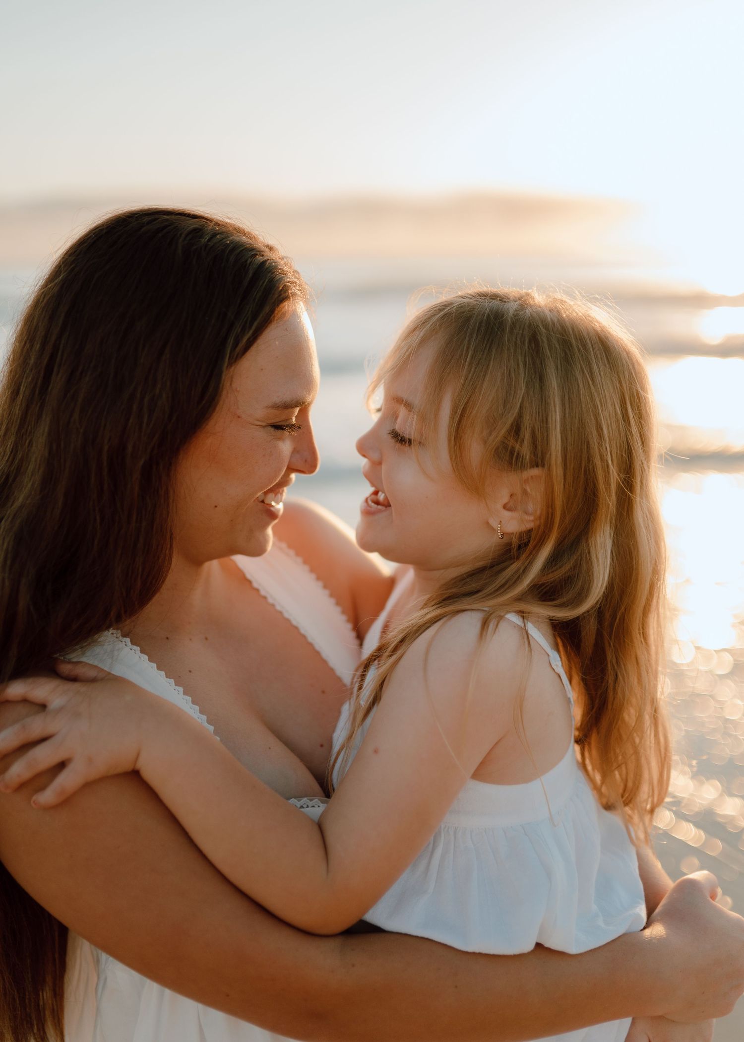 A tender moment captured in a series of photos showing a parent and child embracing on a beach at sunset.