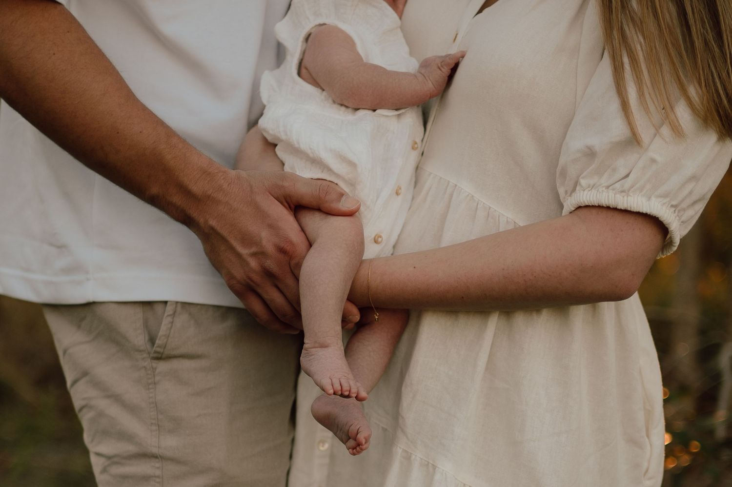 Series of intimate maternity photos showing a pregnant belly in white lace dress.
