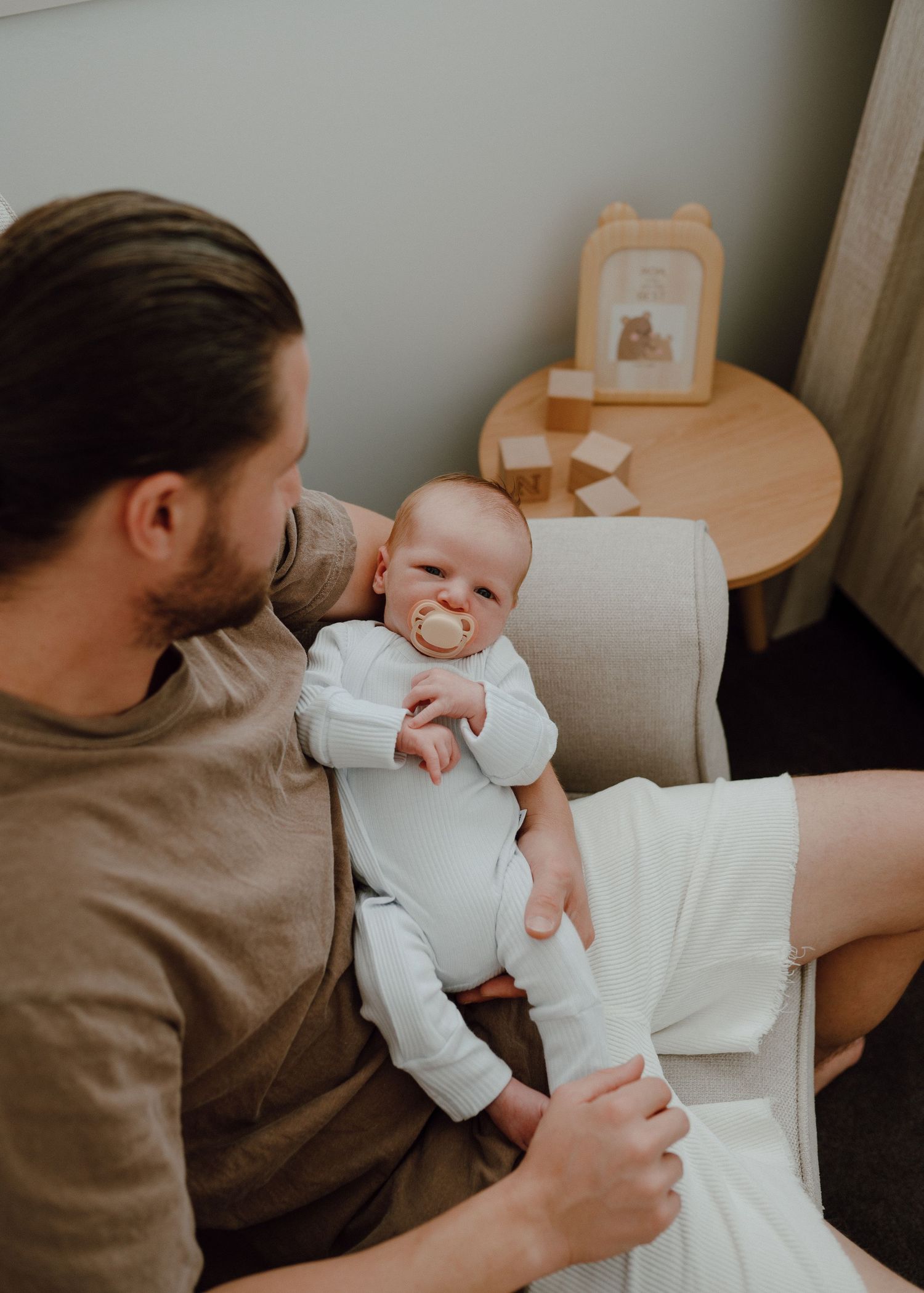 A series of photos showing tender moments between a parent and baby on a couch.