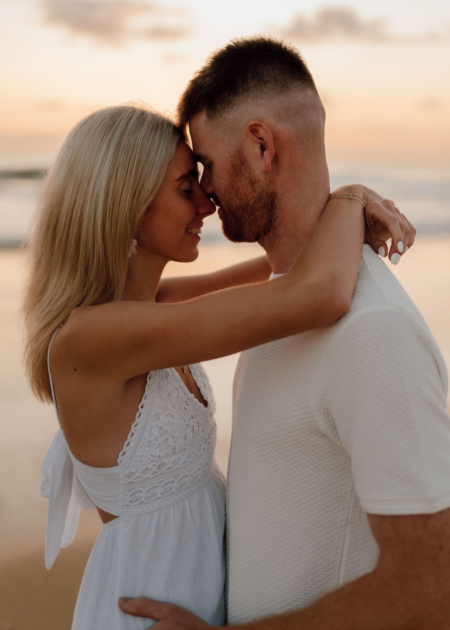A romantic couple shares tender moments at sunset on the beach in a sequence of intimate photographs.
