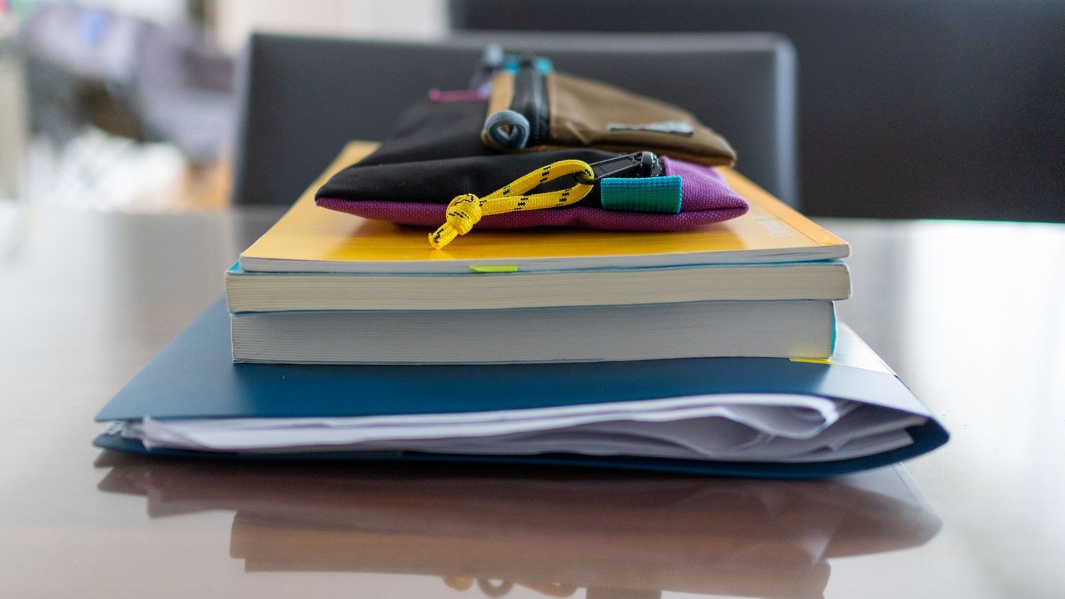 Stacks of neatly folded colorful clothing and textiles arranged on a table.