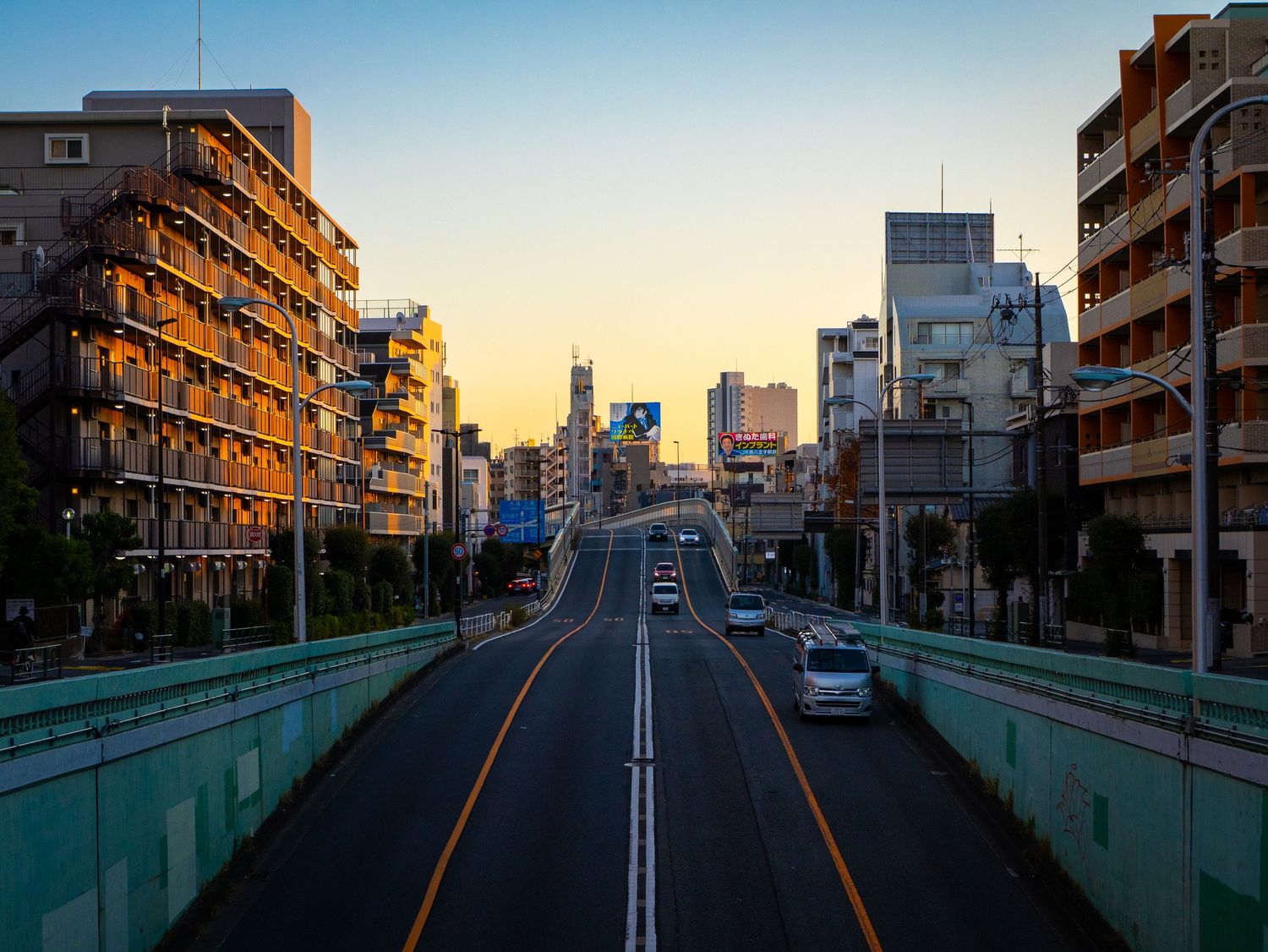 A series of sunset views along an elevated highway with apartment buildings and urban architecture in Japan.