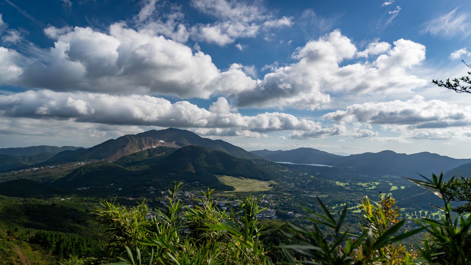 Panoramic mountain landscape with dramatic clouds and rolling hills stretching to the horizon.
