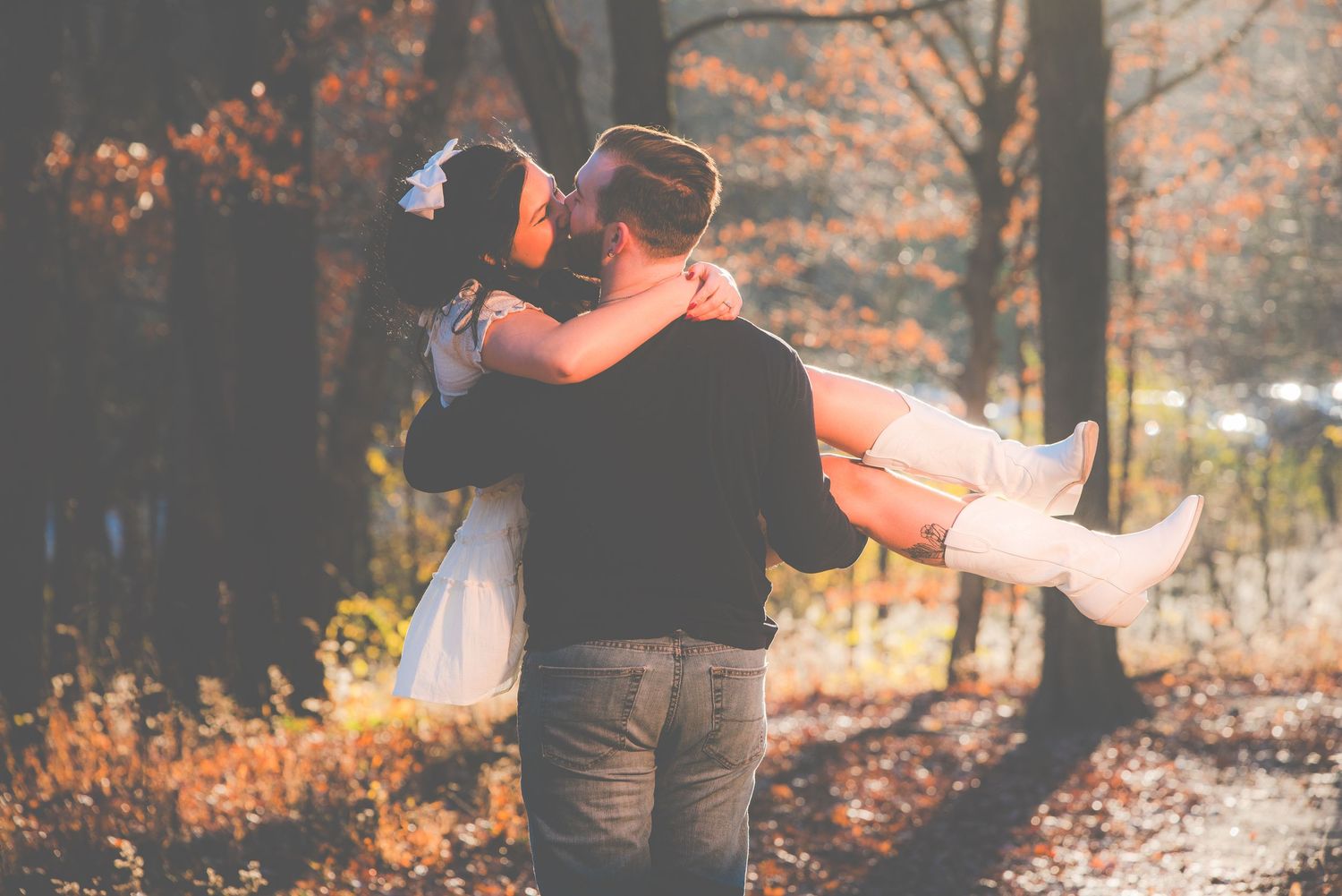 Autumn engagement photoshoot in a forest with warm orange tones and falling leaves.
