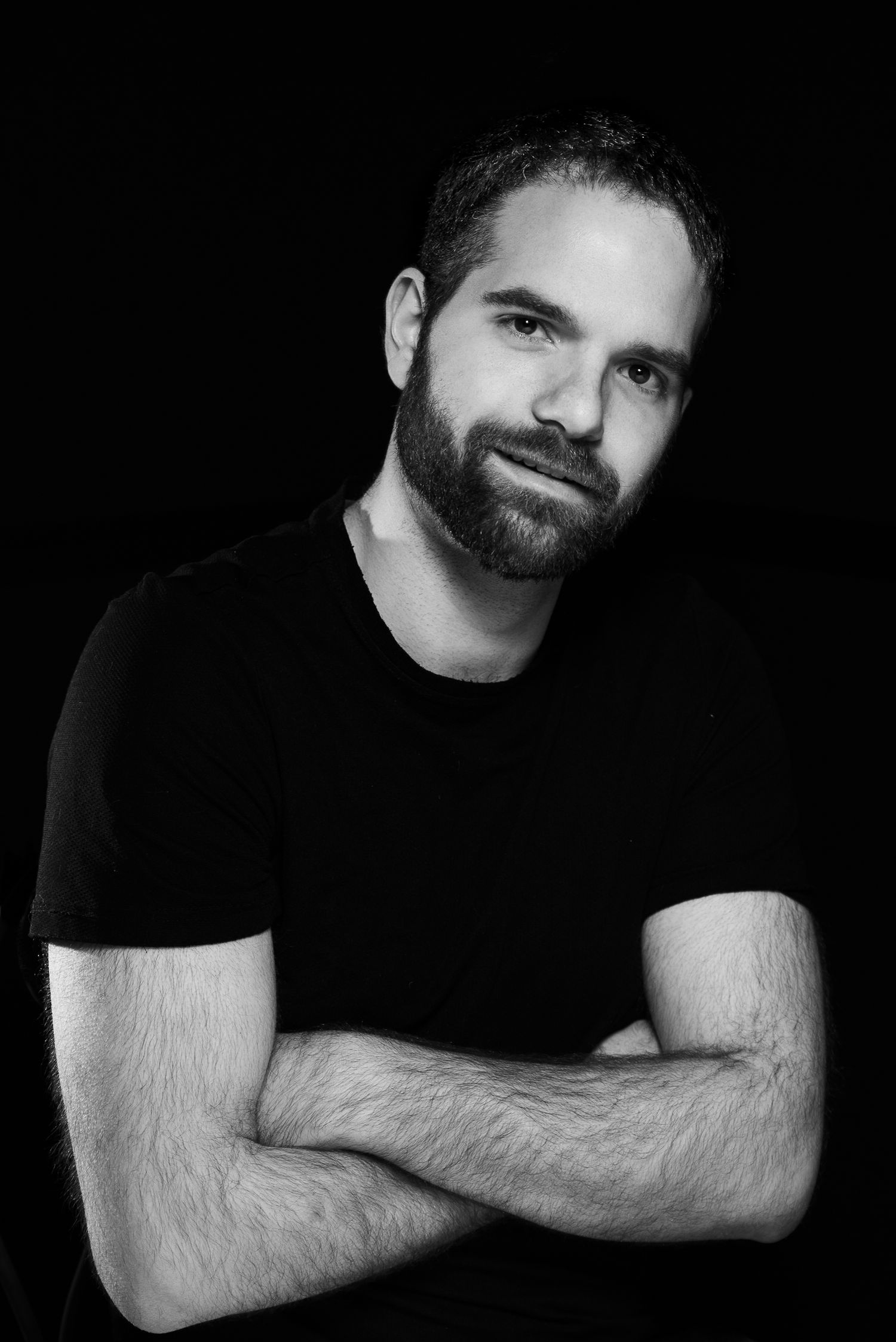 Black and white portrait series showing man in dark shirt against dark background.