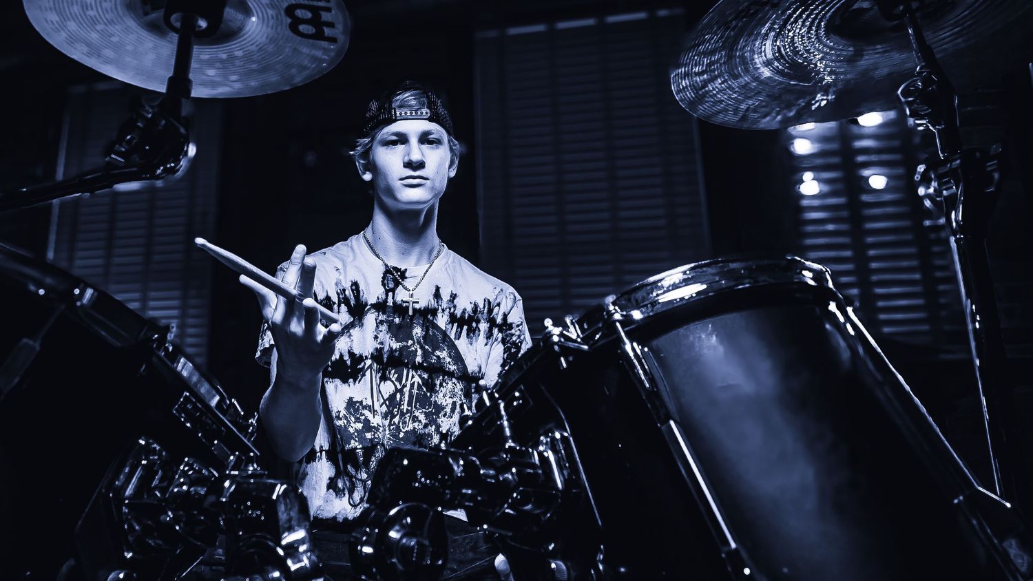 Dramatic monochrome shot of drummer performing behind drum kit.