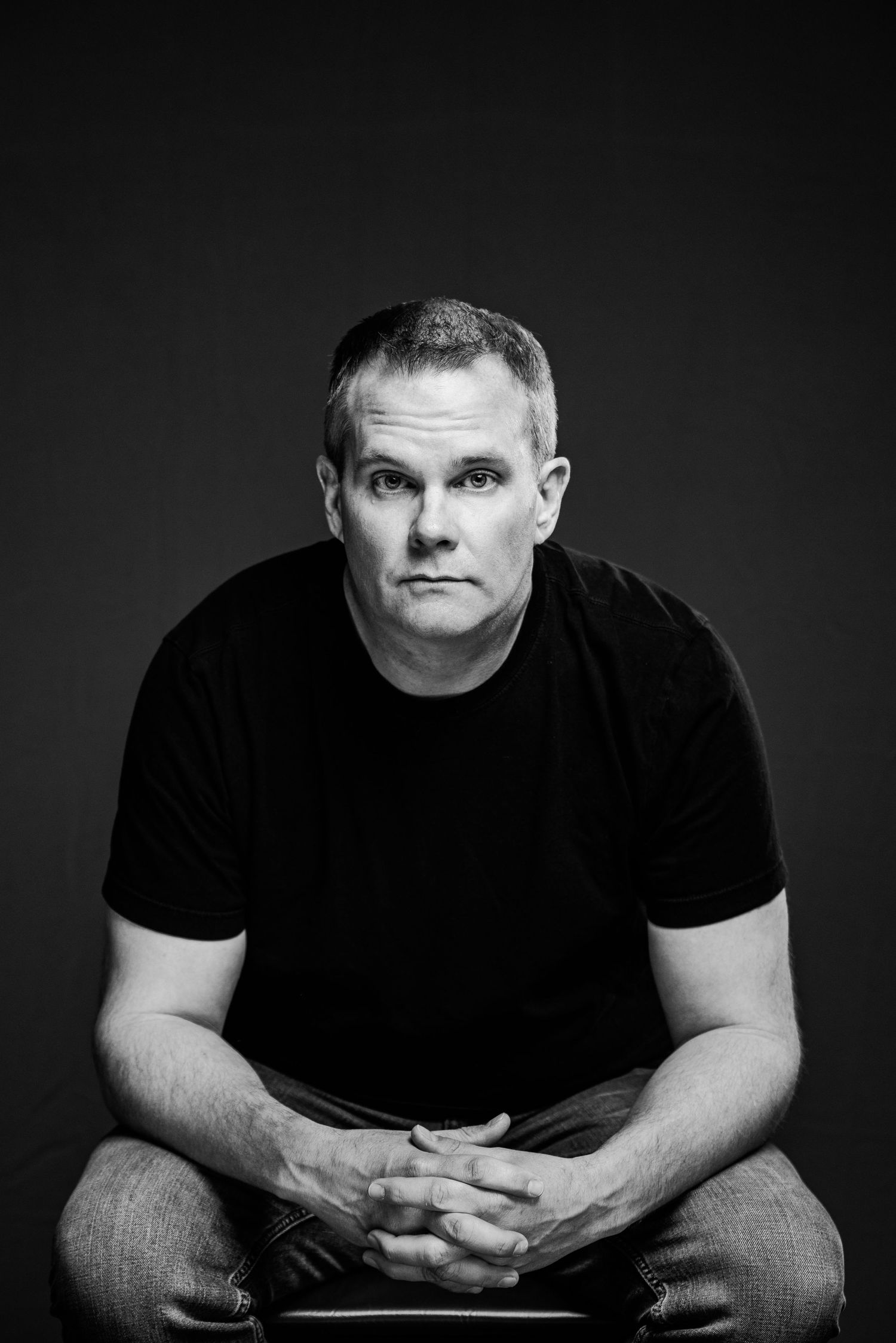 Minimalist black and white portrait series showing contemplative poses against dark background.