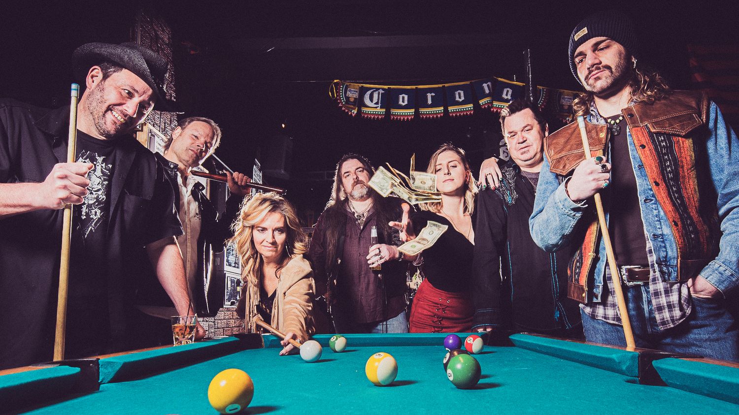 Chicago area cover band Whiskey Road enjoying a game of pool at a bar with drinks and laughter.