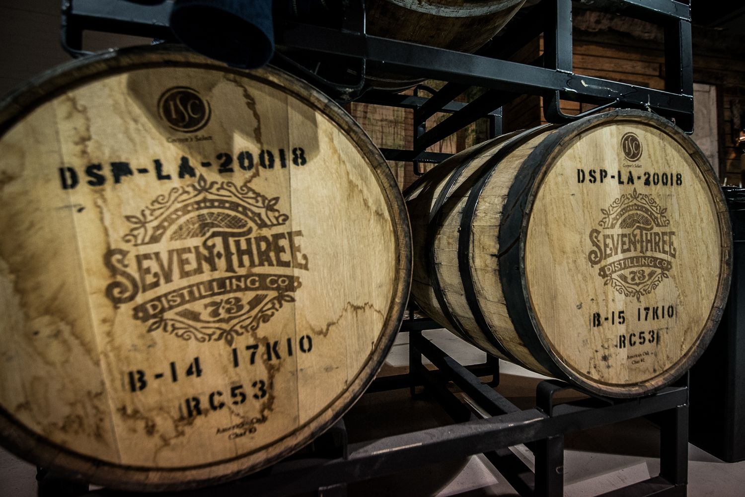 Close-up view of vintage wine barrel labels showing distressed text and aged markings in sepia tones.