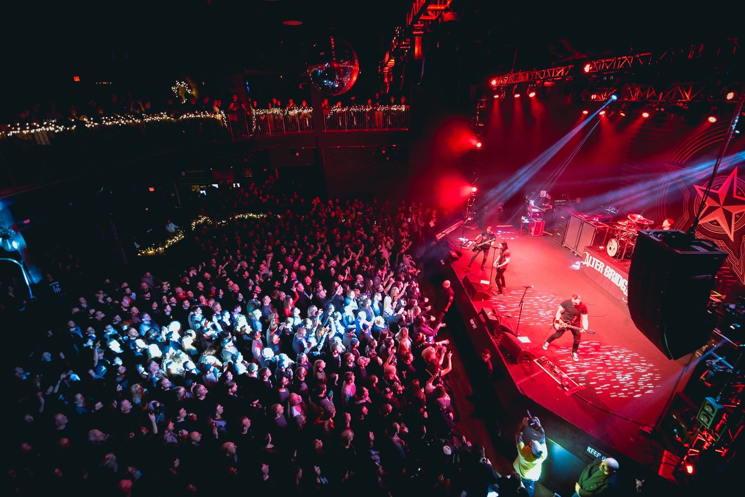 Concert venue photos showing dramatic red lighting and large crowd atmosphere.