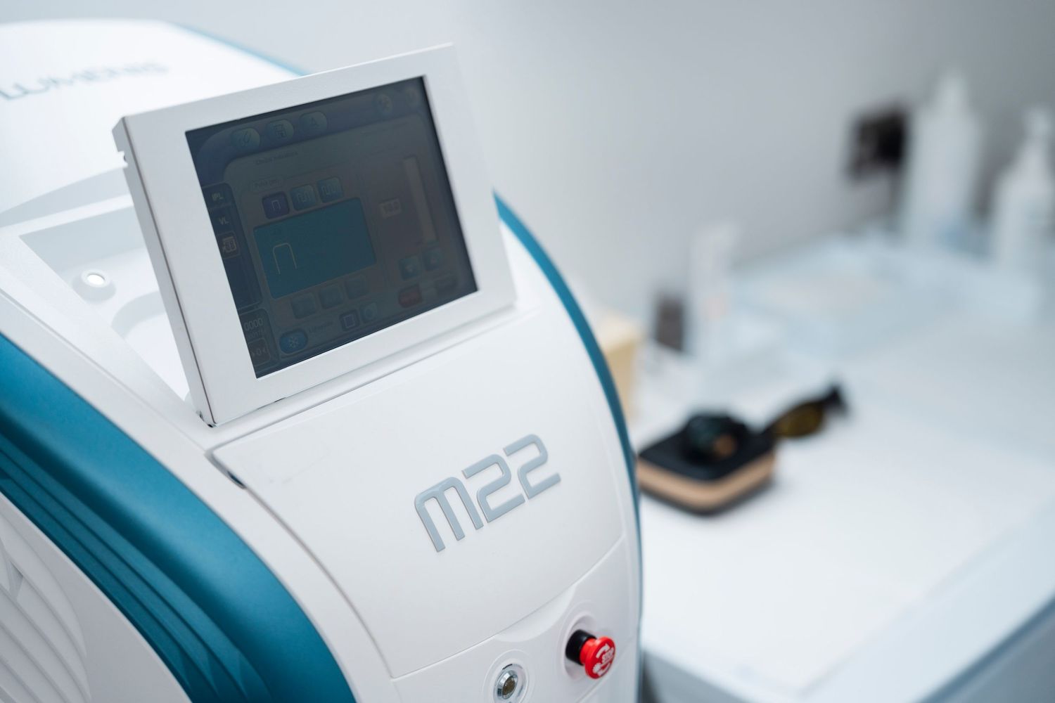 Close-up of M22 laser treatment device with digital screen in professional medical clinic setting. Jenny Flanagan