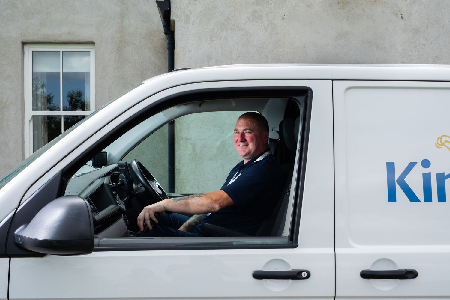 Smiling Kingspan van driver sitting in a white company vehicle ready for a service call. Kingspan Water & Energy