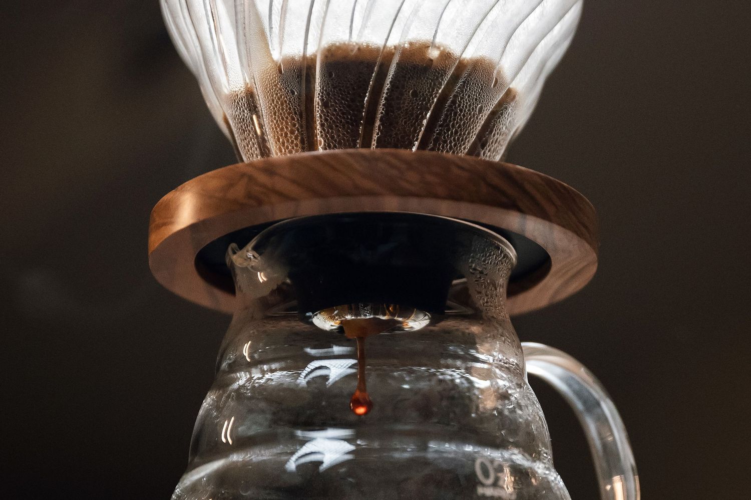 Hot coffee slowly dripping through a pour-over Chemex filter into a glass carafe. Bailies Coffee Roasters