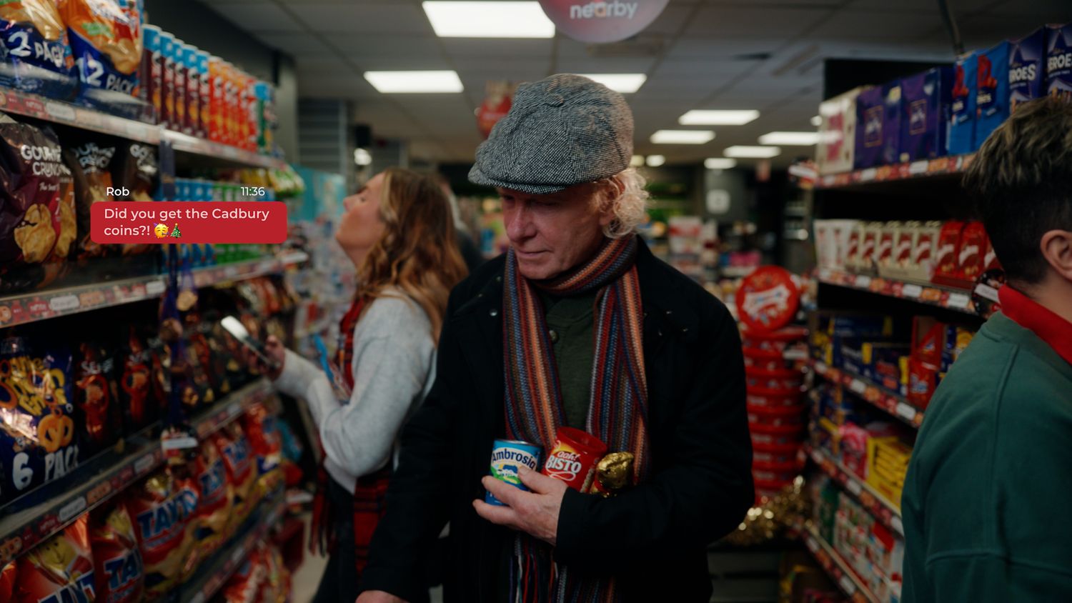 Man in flat cap and colorful scarf shopping in a convenience store candy aisle at Christmas. Nearby Stores, S&W wholesale, TV Advert