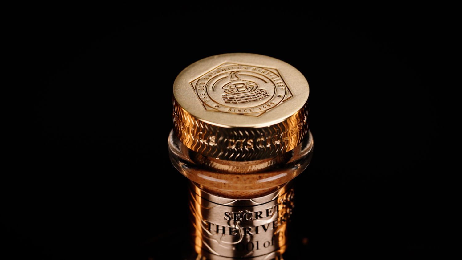 Gold embossed bottle cap of Bushmills Secrets of the River Bush aged whiskey. Bushmills Whiskey