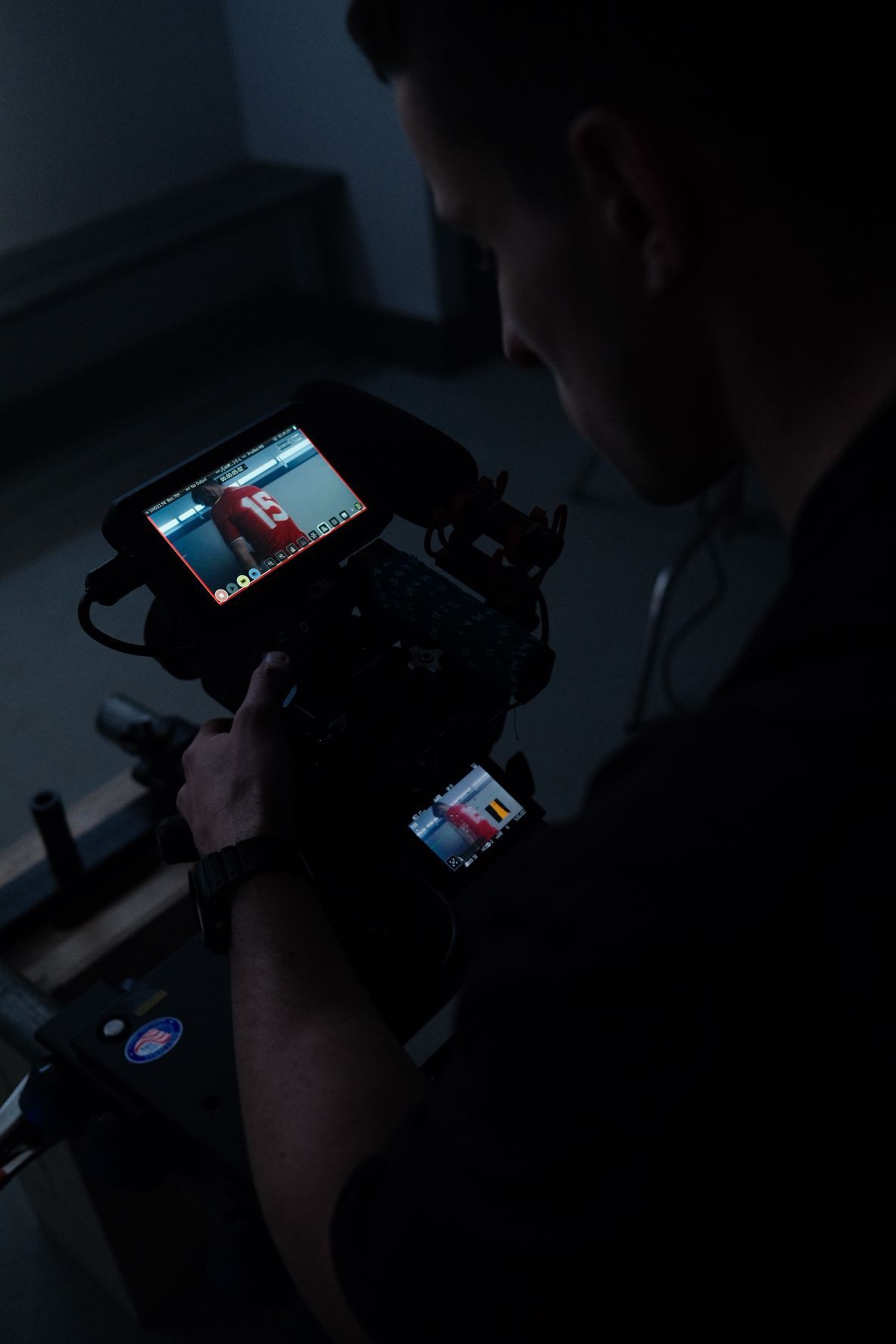 Cinematographer reviews footage on a professional camera monitor in a dark studio setting. Ulster GAA