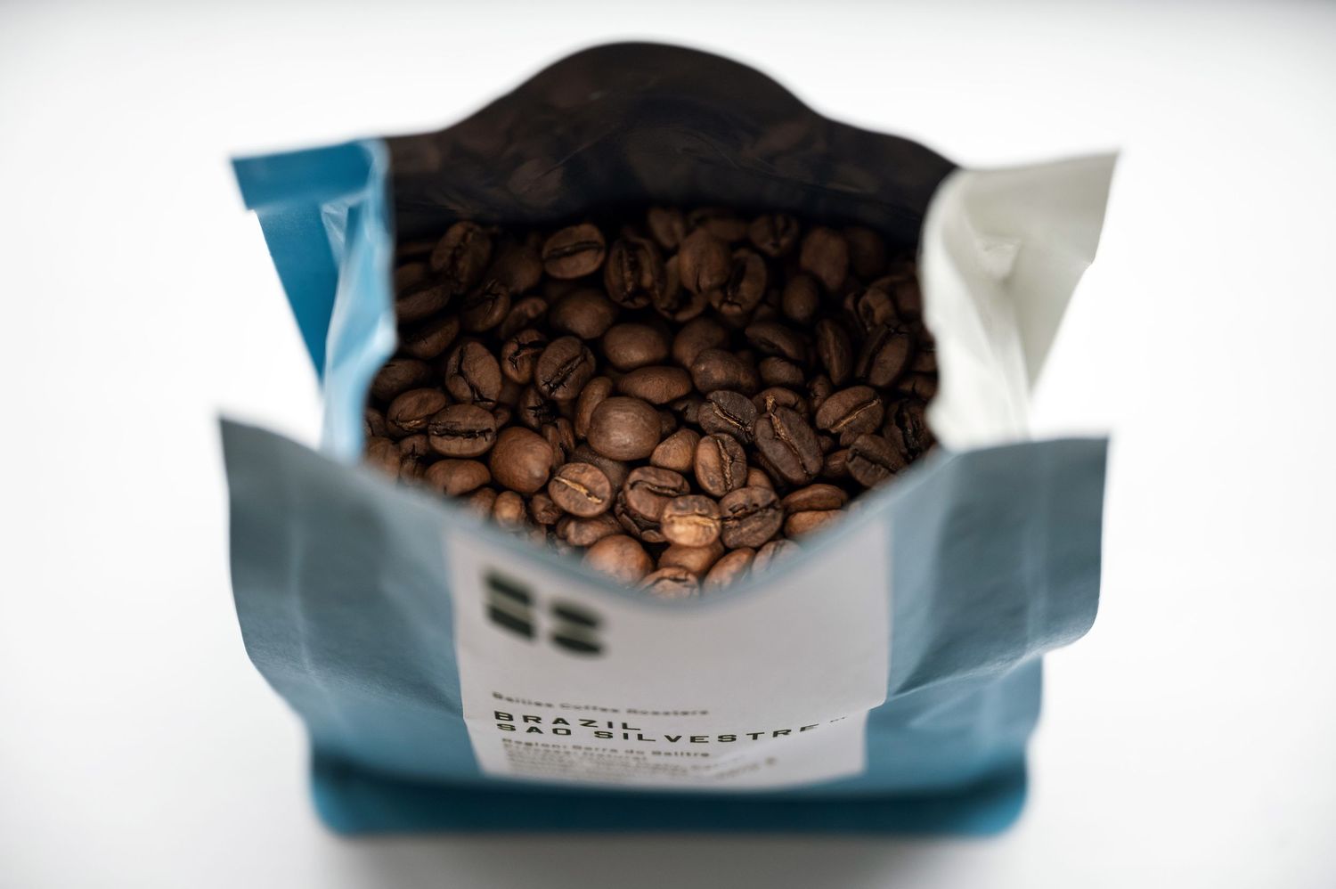 Open bag of roasted coffee beans with a Swedish flag label, showcasing fresh specialty coffee. Bailies Coffee Roasters