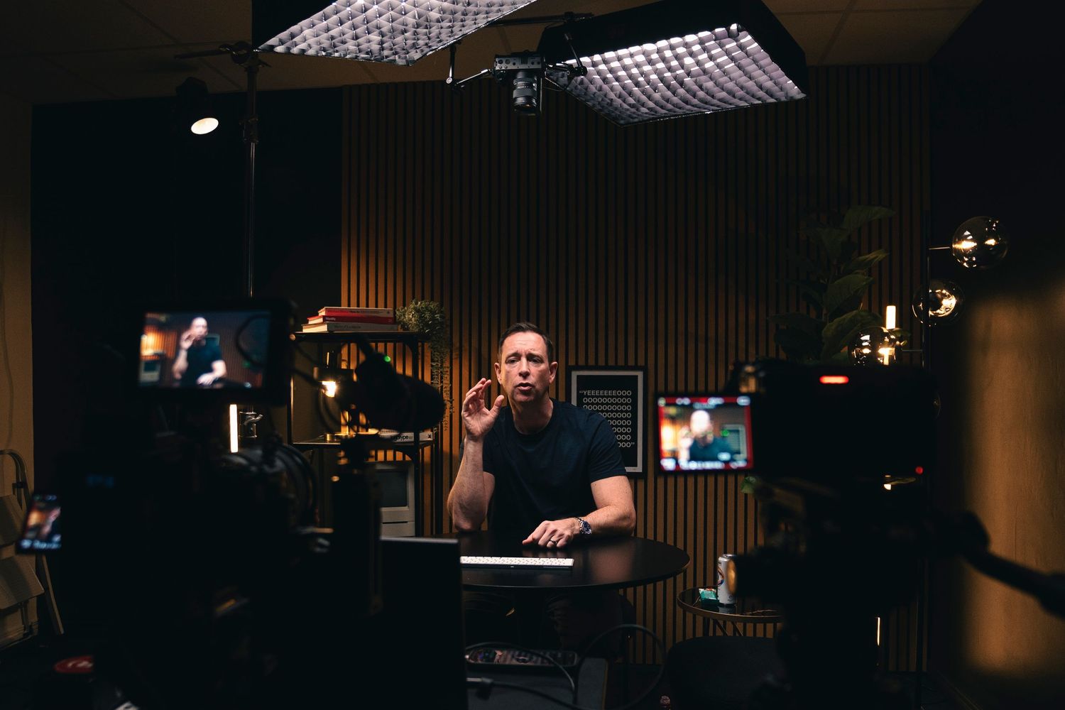 content creator sits at desk with professional lighting equipment in record room studio setup