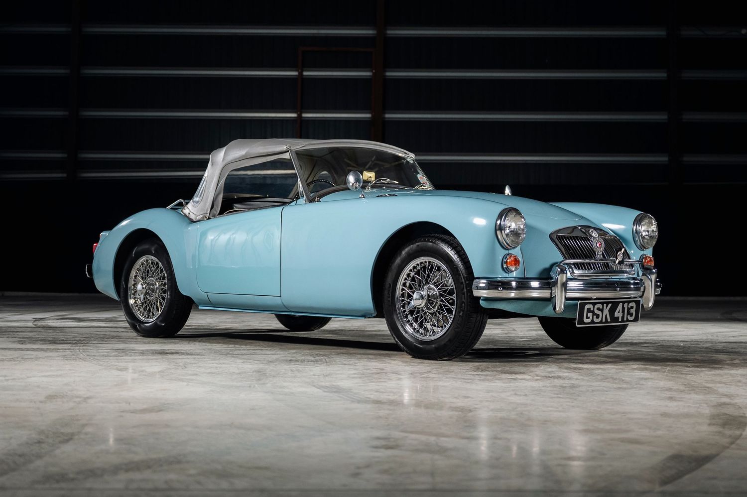Light blue MGA classic British sports car with hardtop and wire wheels, registration GSK 45, indoors. Motorist Collection
