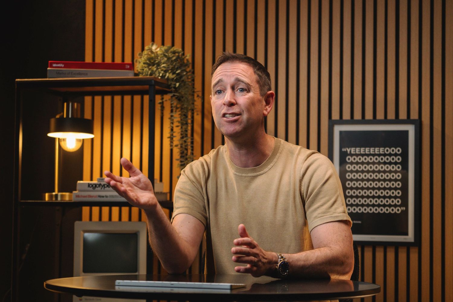 Connor McAuley Move At Pace gesturing while speaking in a modern studio with wooden panel walls and warm lighting.