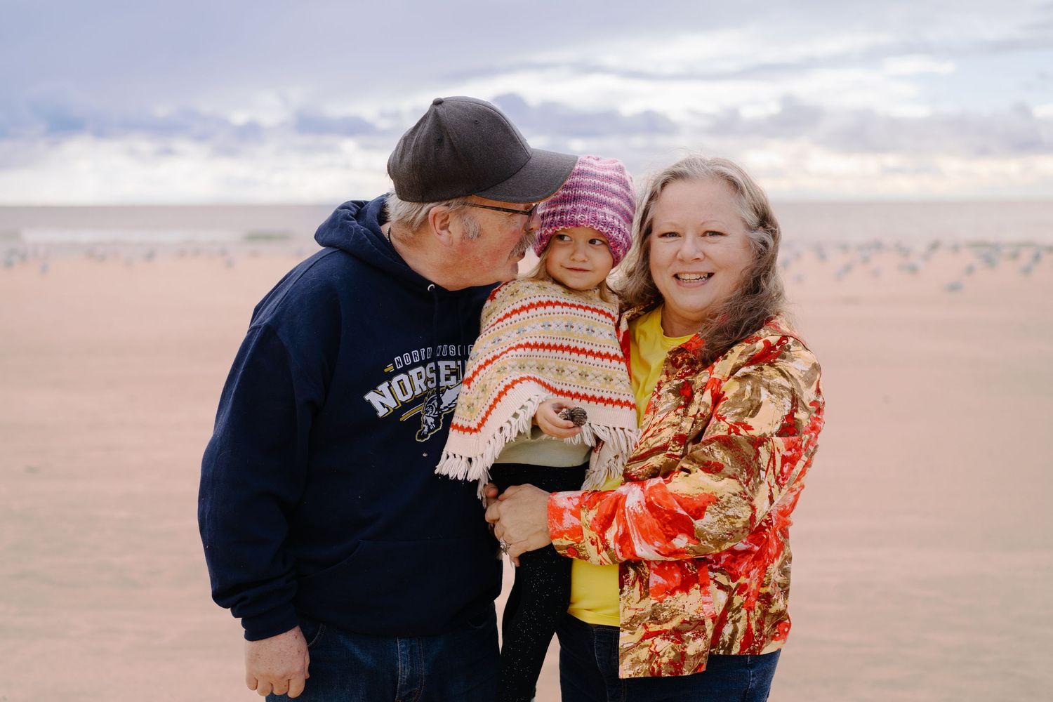 A heartwarming family moment captured at the beach during golden hour.