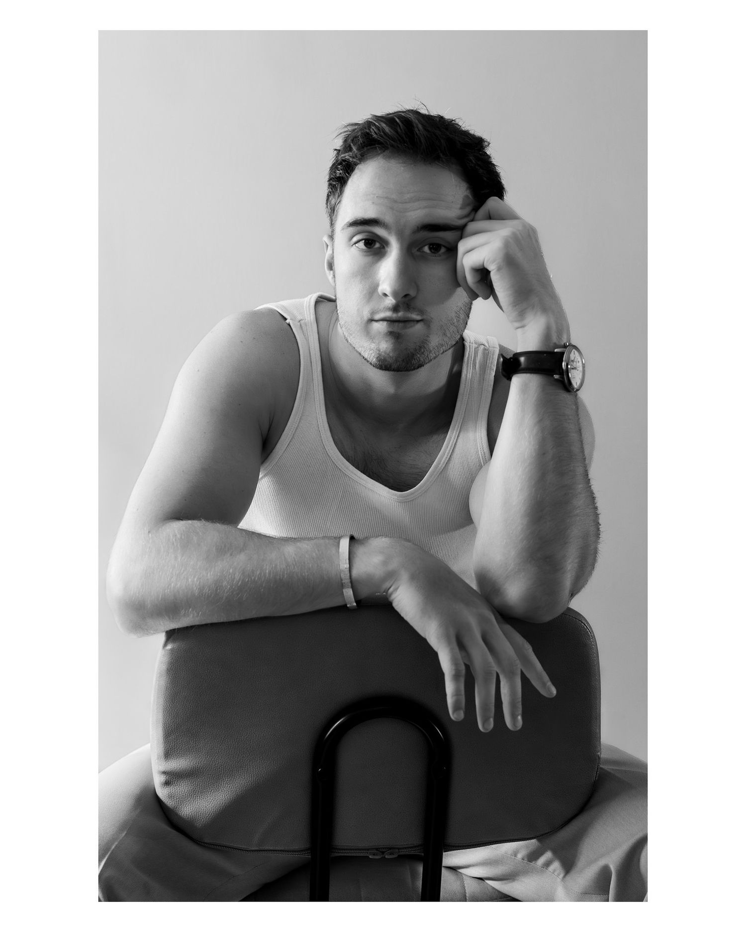 Man sitting on chair, in black and white