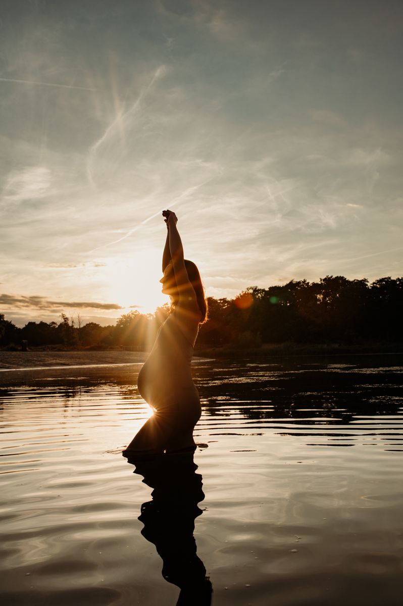 Silhouetfoto van een zwangere vrouw tijdens zonsondergang