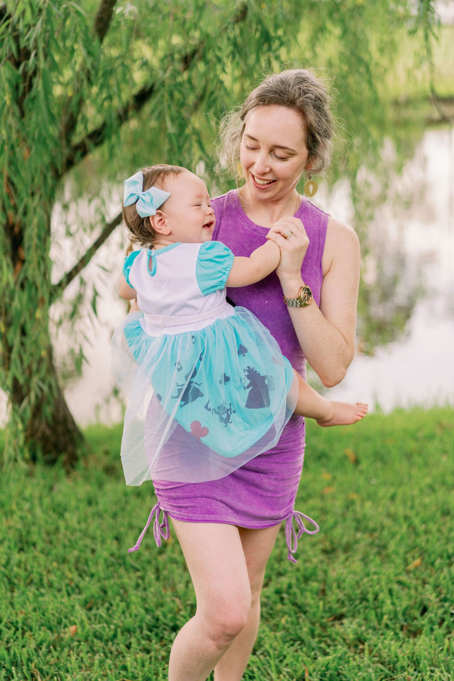 Playful moment captured outdoors under a weeping willow tree.
