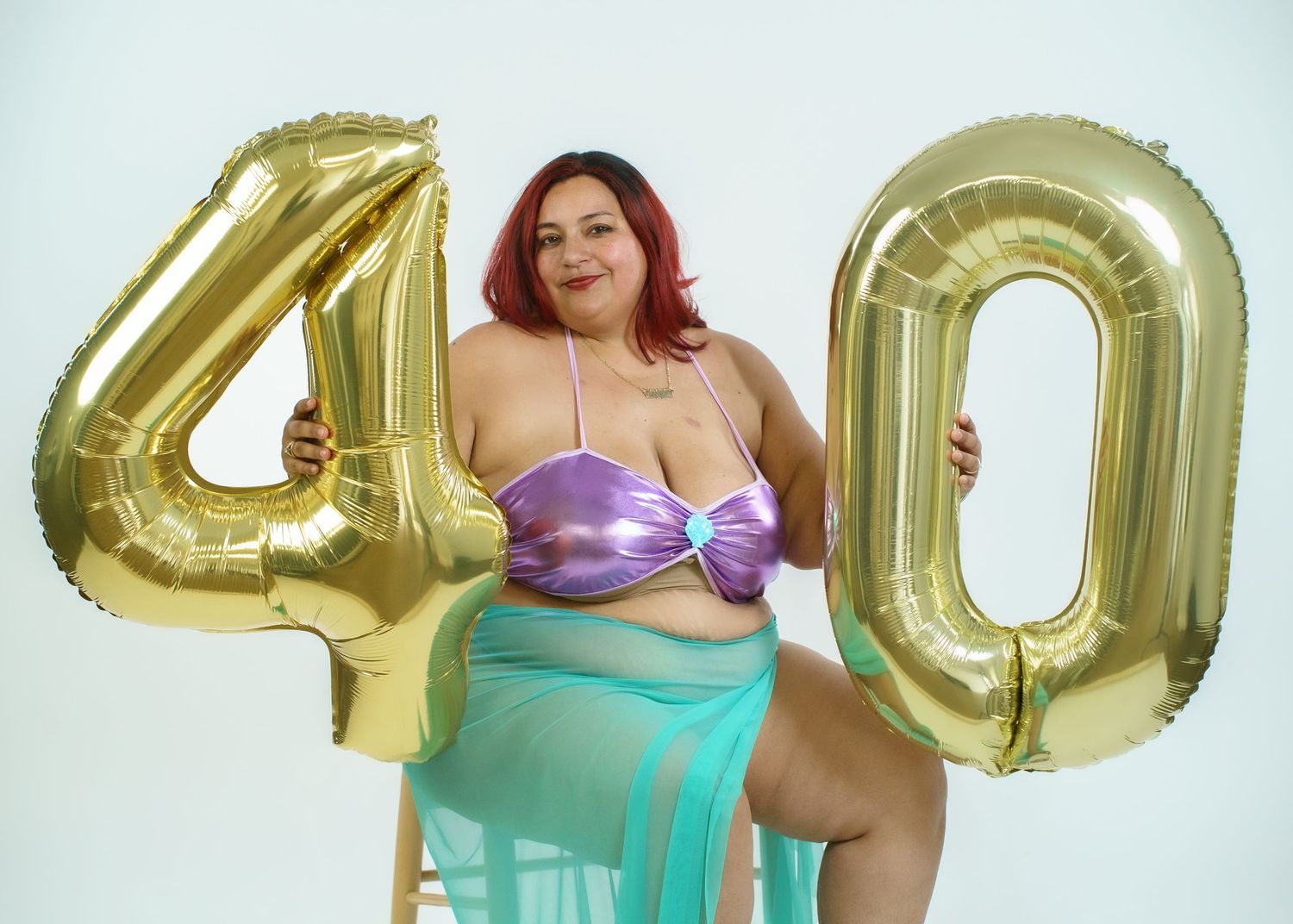 Fashion photography with gold metallic number balloons and mint accents.