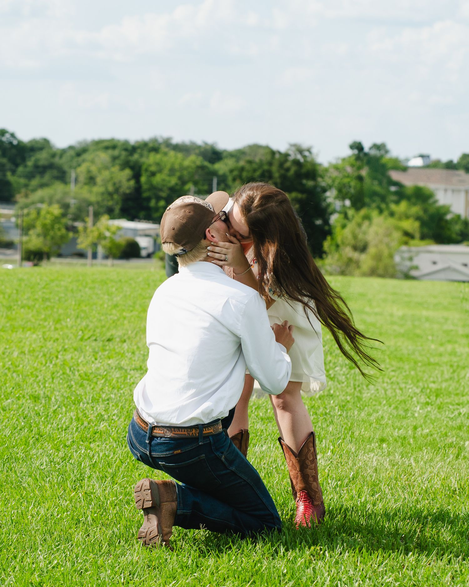 Two people share a playful moment on a bright green lawn.