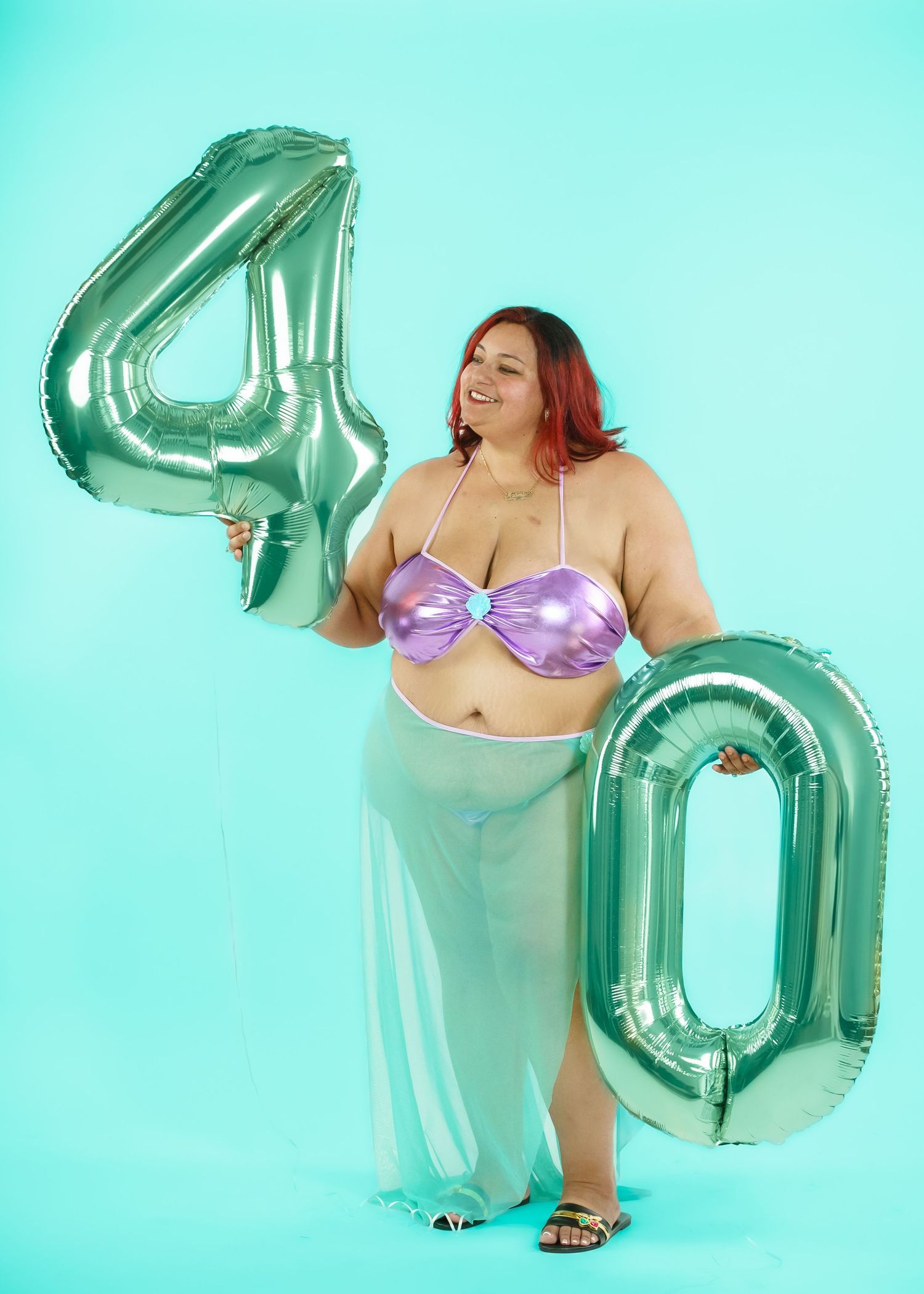 Boudoir photoshoot with metallic number balloons against turquoise background.