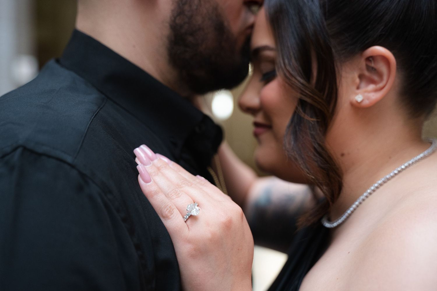 Close-up romantic moment between couple in formal attire.