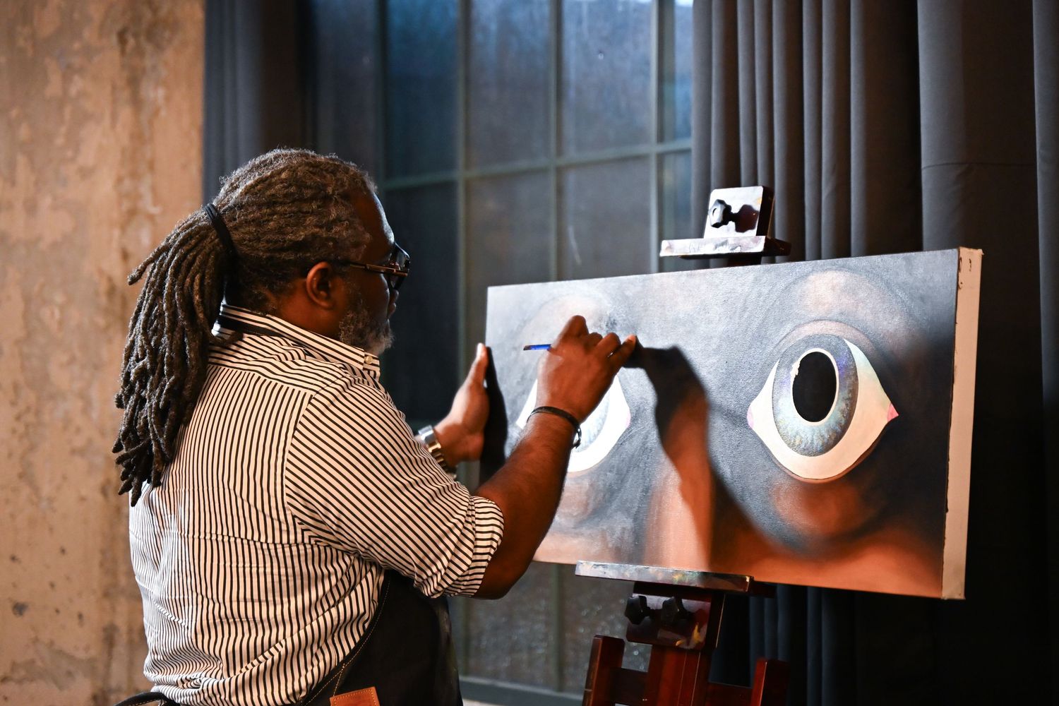 A sequence of black and white photographs showing someone drawing a portrait in stages on a white surface.