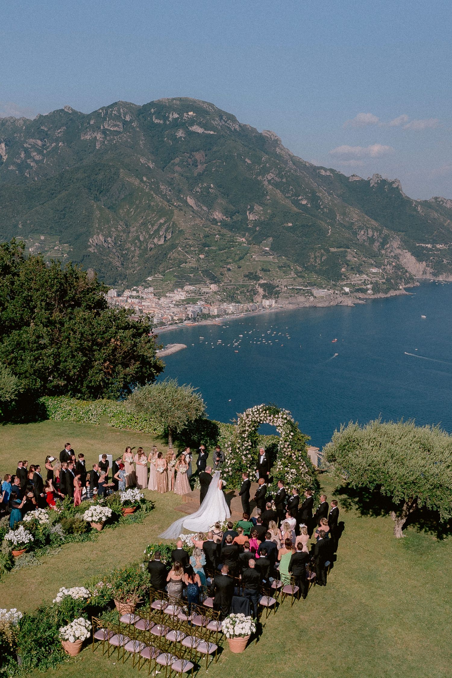 An wedding ceremony in the garden of two fountains at Villa Cimbrone overlooking the Amalfi Coast in Italy with Sea in backdrop.