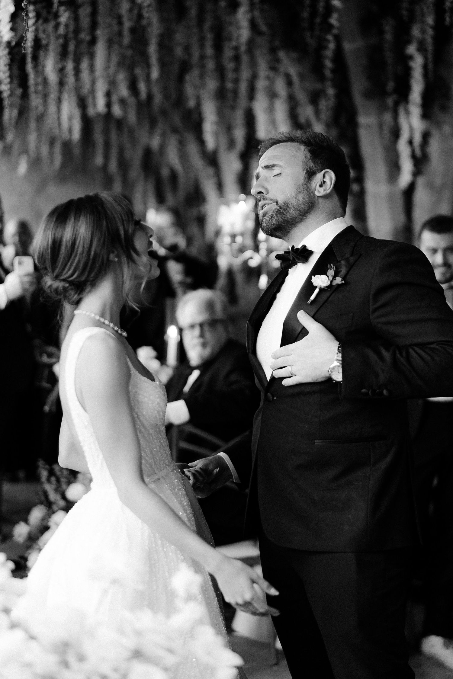 A bride and groom share a romantic dance moment in black and white at their wedding reception.