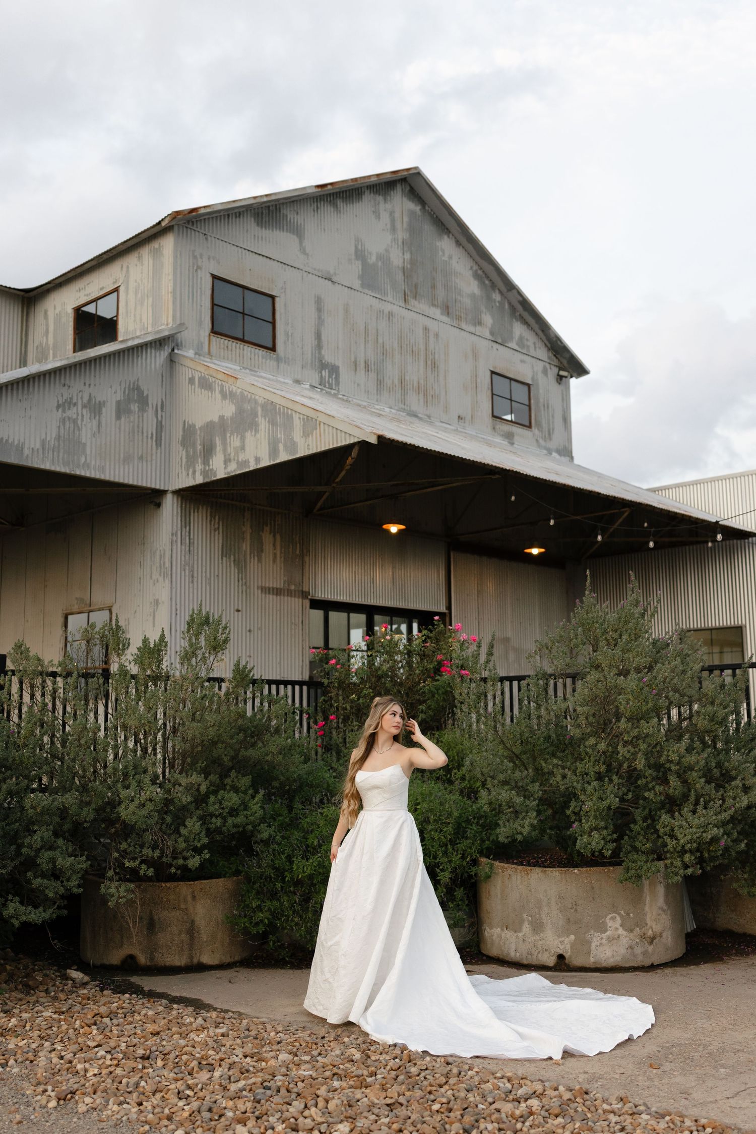 A sequence of five wedding photos showing a white gown against an industrial warehouse backdrop with rustic landscaping.