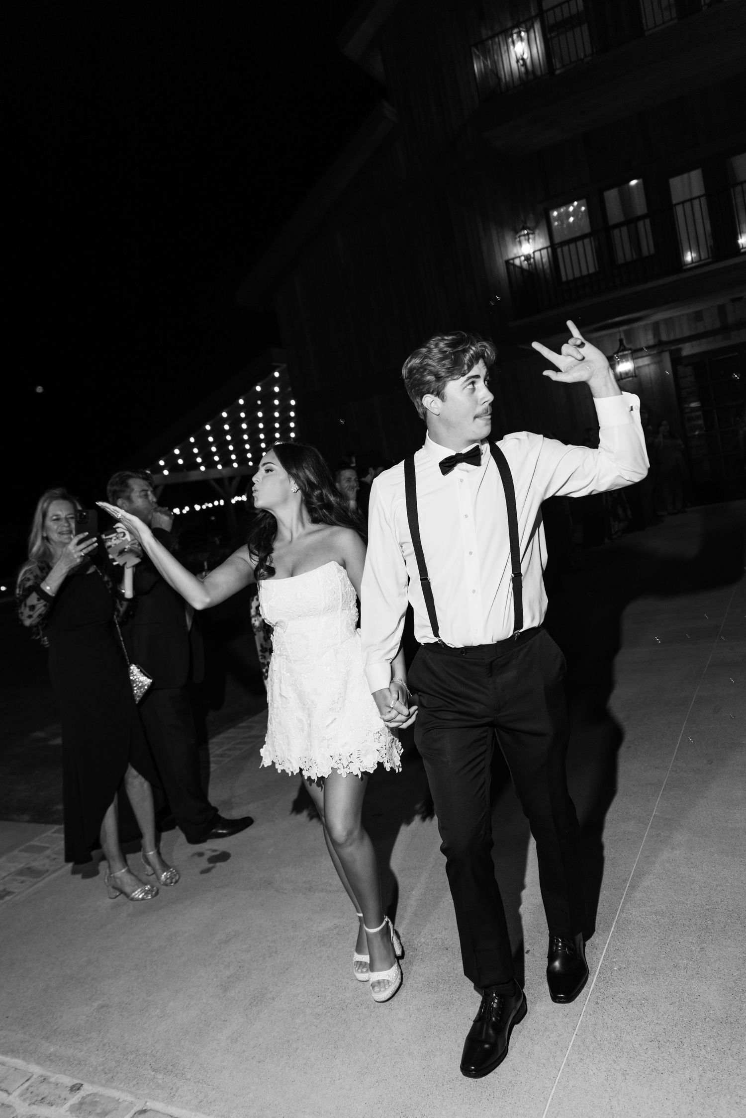 Black and white sequence of couples dancing at a formal event with the bride in white and groom in suspenders.