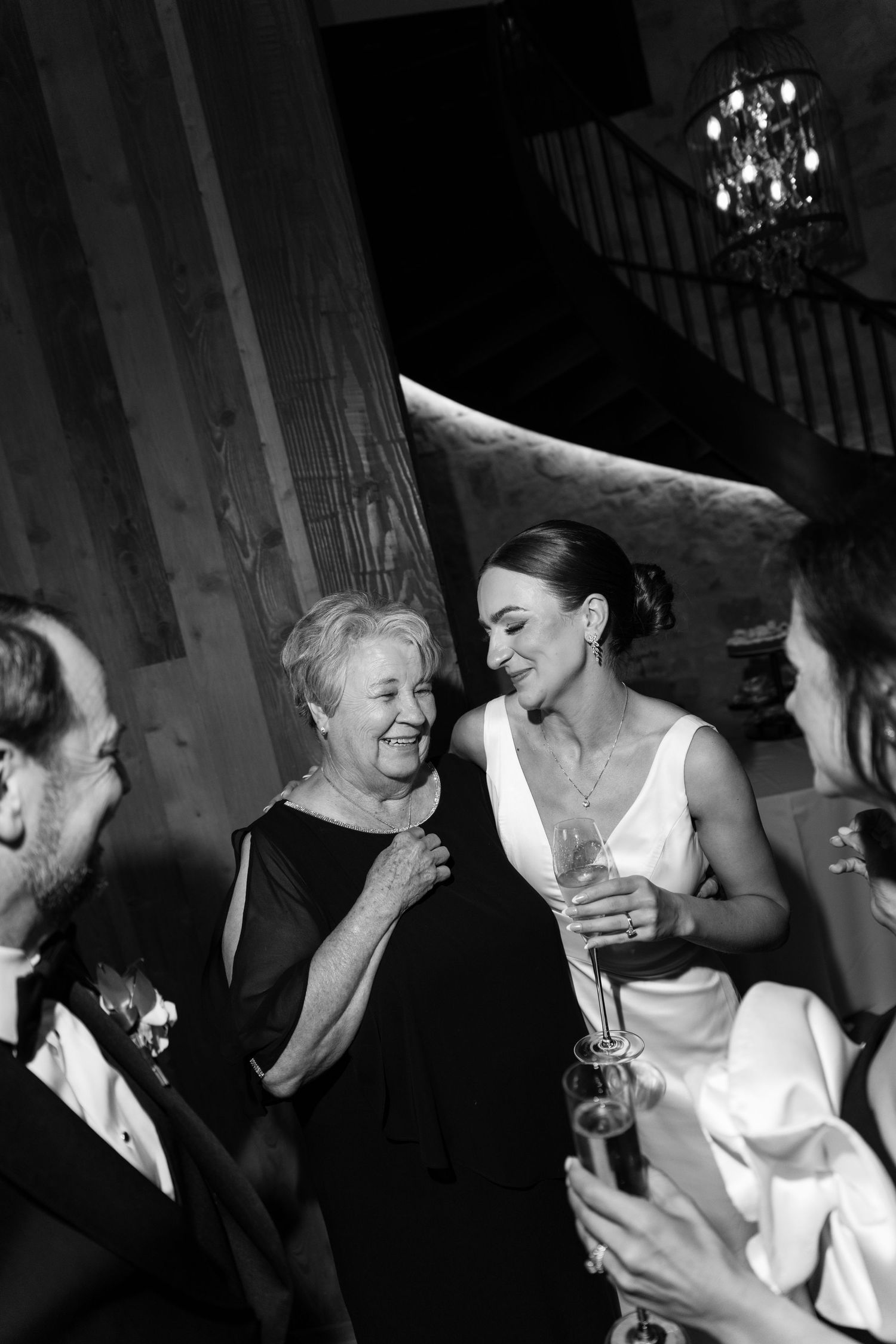 A sequence of black and white candid photos showing joyful laughter and intimate moments at what appears to be a wedding celebration.