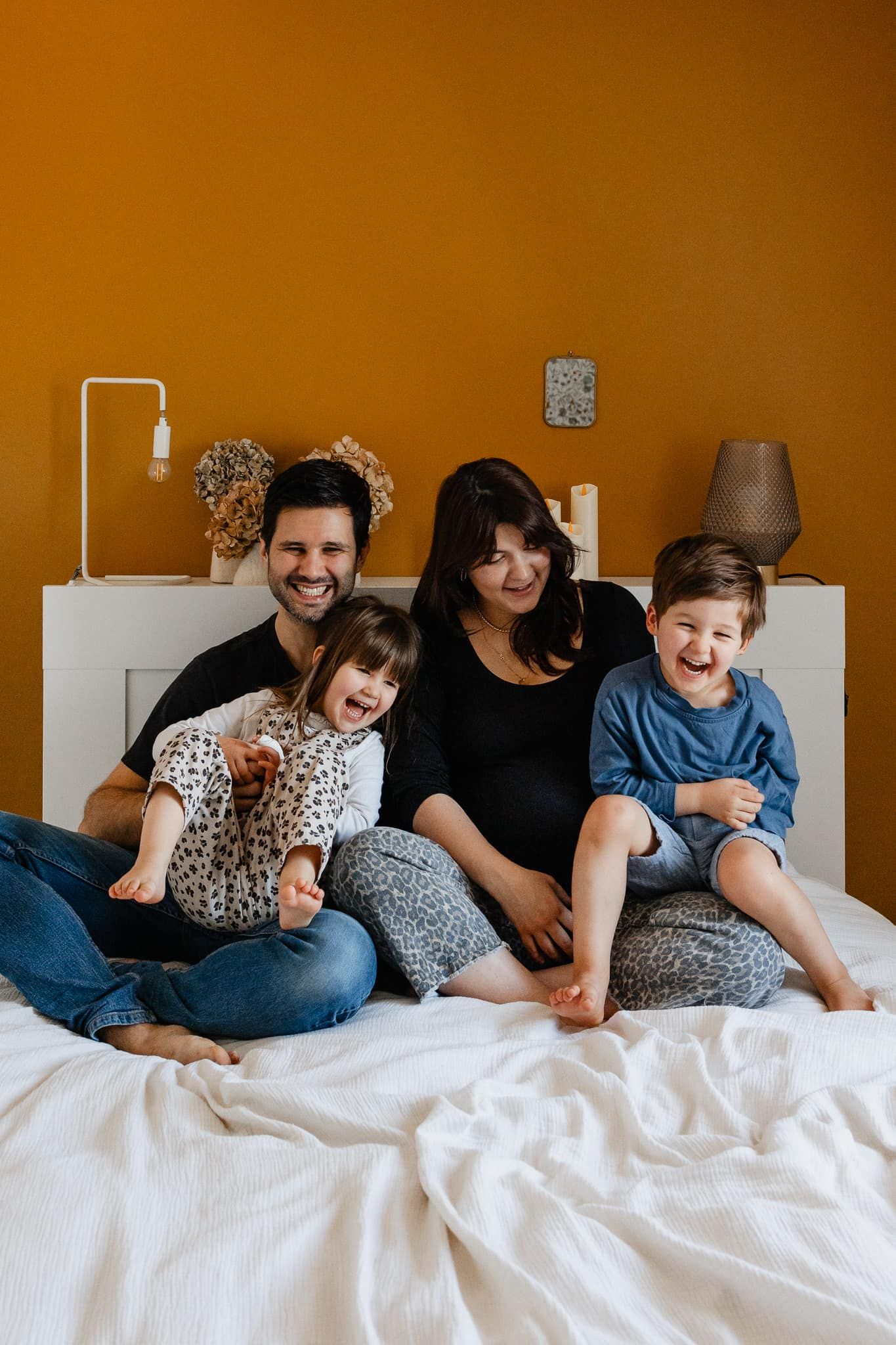 seance photo lifestyle a domicile a La Madeleine pres de Lille, une famille joue et fait des calins sur le lit dans la chambre des parents